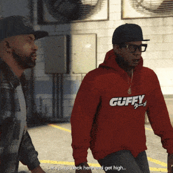 a man wearing a red hoodie that says " guffy " talks to another man