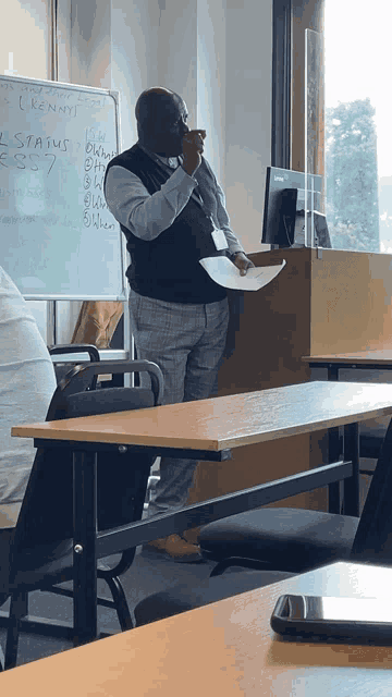 a man stands in front of a whiteboard that says kenny on it