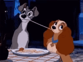 a couple of cartoon dogs eating spaghetti at a table .