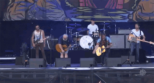 a group of men are playing instruments on a stage with a sign that says keep calm