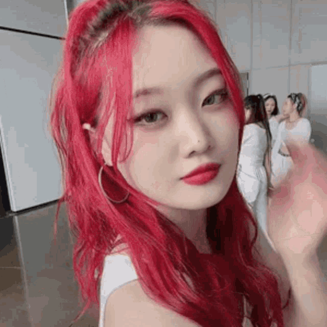 a woman with red hair and red lipstick is standing in a room .