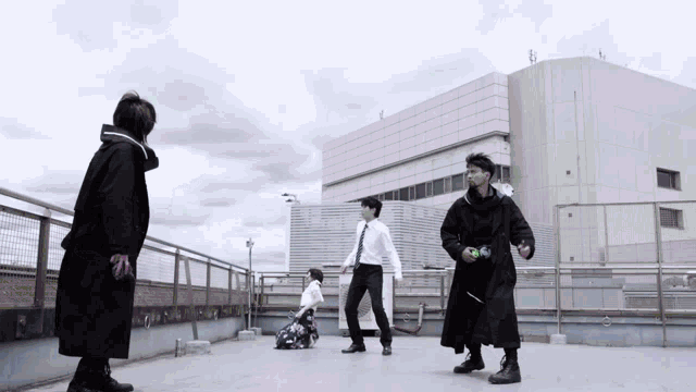 a group of people are standing on a rooftop with a building in the background