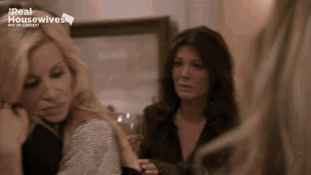 two women are standing next to each other in front of a screen that says real housewives out of context