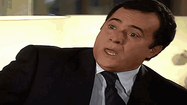 a man in a suit and tie making a face