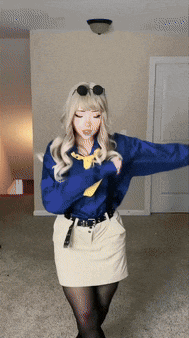 a woman in a blue shirt and white skirt dancing