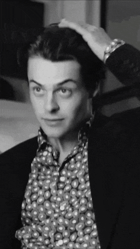a man in a polka dot shirt is being touched by another person