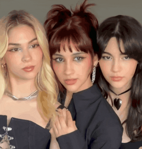 three women posing for a picture with one wearing a heart shaped necklace