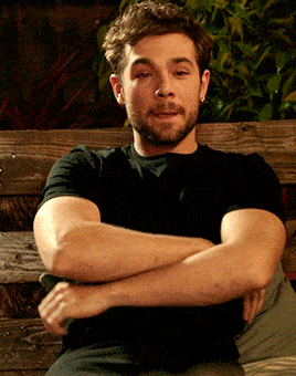 a man with his arms crossed looks at the camera