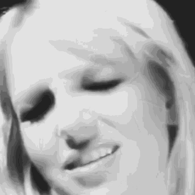 a close up of a woman 's face in a black and white photo with her eyes closed .