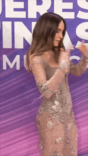 a woman in a dress is standing in front of a sign that says eres