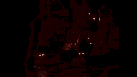 a dark room with a few lights shining through the windows