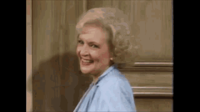 a close up of a woman smiling in front of a door .
