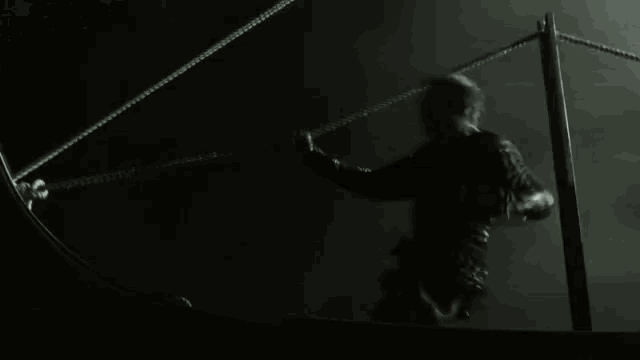 a black and white photo of a person holding a rope in the water