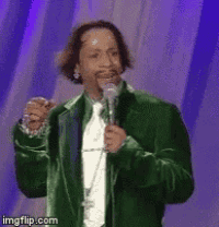 a man in a green jacket and tie is singing into a microphone ..