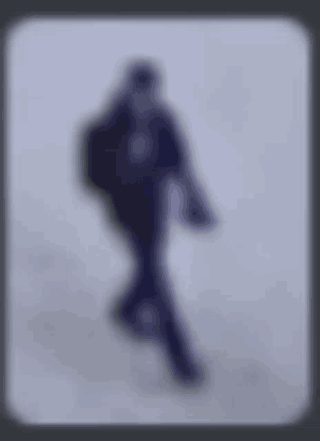 a blurry picture of a person walking on a snowy surface .