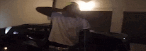 a man is sitting in a chair in a dark room with his hands behind his head .