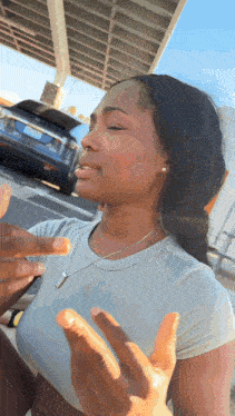 a woman is talking to a man in a parking lot while a car is parked in the background .