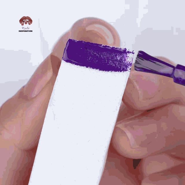 purple nail polish is being applied to a sponge