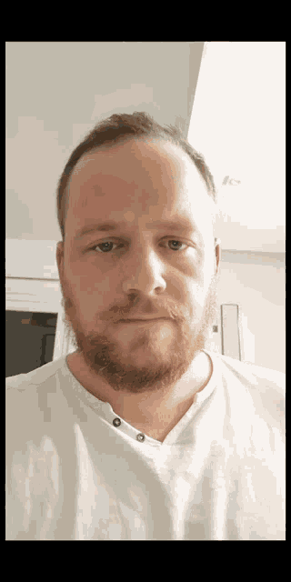 a man with a beard wears a white shirt