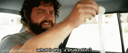 a man with a beard is sitting in a car holding a condom and asking what is this a snakeskin