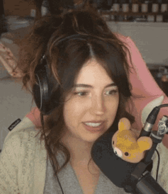 a woman wearing headphones and a microphone with a stuffed animal on it