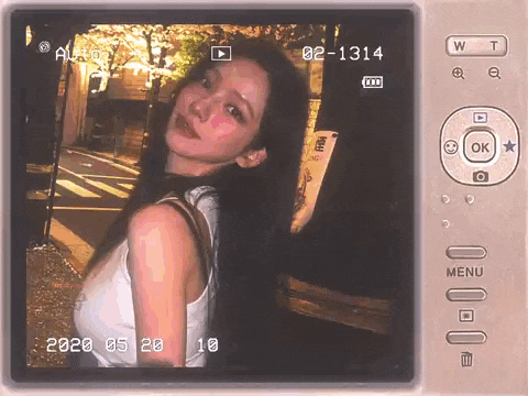 a woman in a white tank top is being recorded on a camera .
