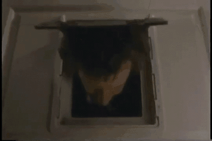 a man 's head is visible through a hole in a wall