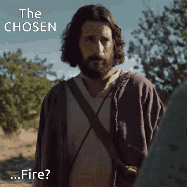 a man with a beard is standing in a field with the words " the chosen " above him