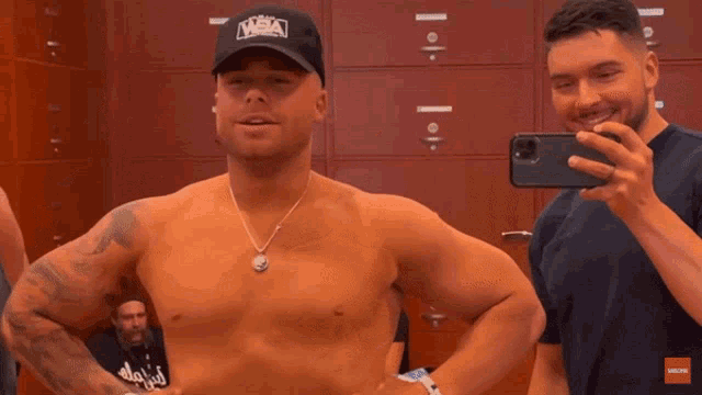 a man taking a picture of himself in a locker room wearing a hat that says mma