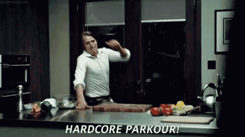 a man is doing a hardcore parkour in a kitchen while preparing food .