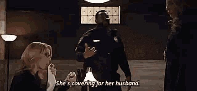 a police officer is talking to two women in a room .