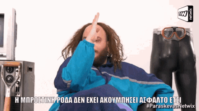 a man in a blue jacket is giving the middle finger in greek