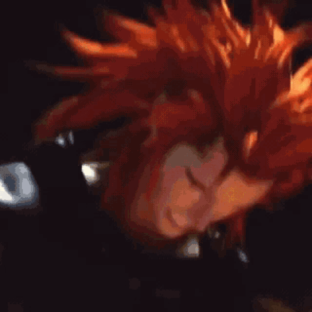 a woman with red hair is standing in front of a fire in a dark room .