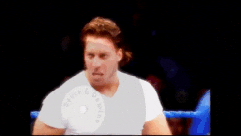 a man in a white shirt is standing in a ring