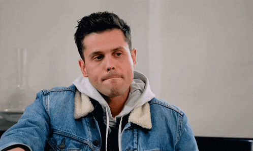a man wearing a denim jacket with a white collar