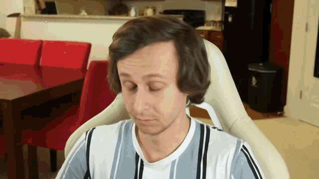 a man with his eyes closed is sitting in a chair