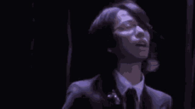a man in a suit with purple wings is playing a guitar .
