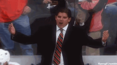 a man in a suit and tie with his arms outstretched in front of a crowd