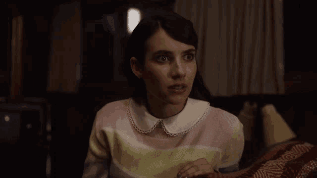 a woman in a striped sweater with a white collar is making a surprised face