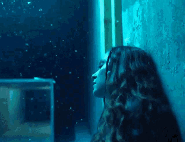 a woman is looking out of a window at the snow