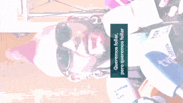 a man wearing sunglasses is surrounded by microphones and a sign that says " queremos follar "