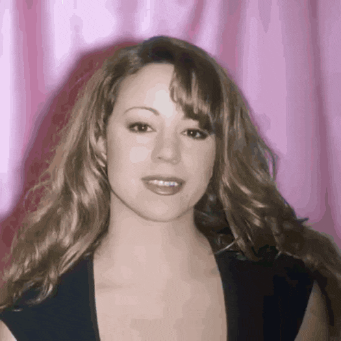 a close up of a woman 's face against a pink curtain