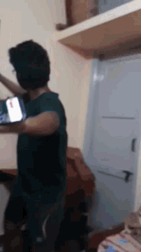 a man is doing push ups in a room with a cell phone on his arm .