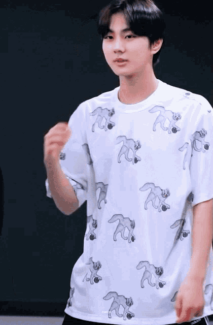 a young man wearing a white t-shirt with a pattern of foxes on it