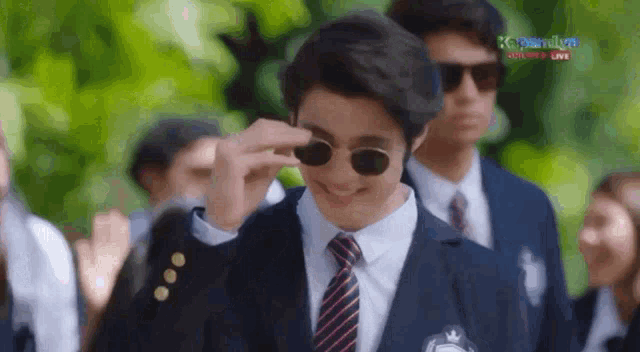 a man in a suit and tie is wearing sunglasses and smiling ..