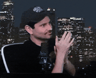 a man wearing a hat that says ' heavy metal ' on it stands in front of a city skyline