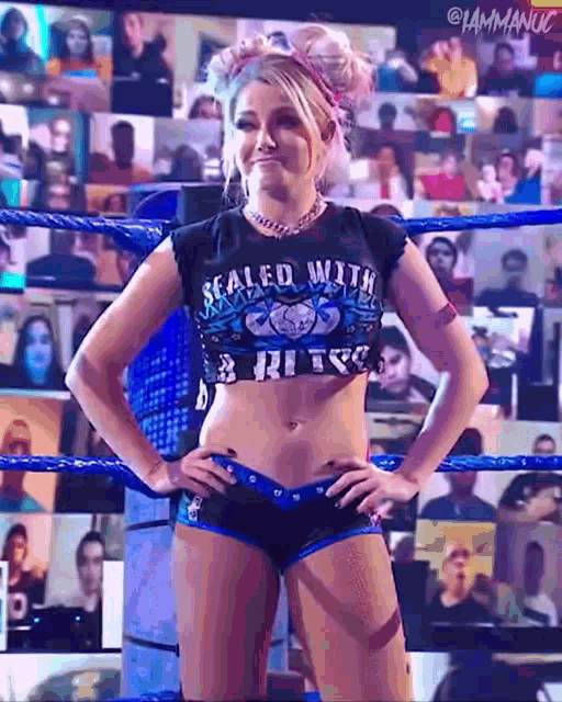 a woman is standing in a wrestling ring wearing a crop top that says sealed with a bite .