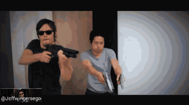 two men holding guns in front of a screen that says jeffwingersego
