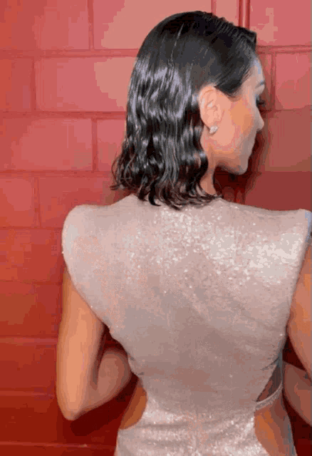 the back of a woman 's dress is shown against a red wall