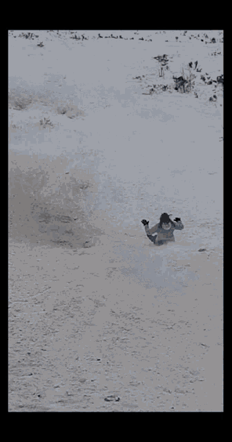 a person is sliding down a hill in the snow